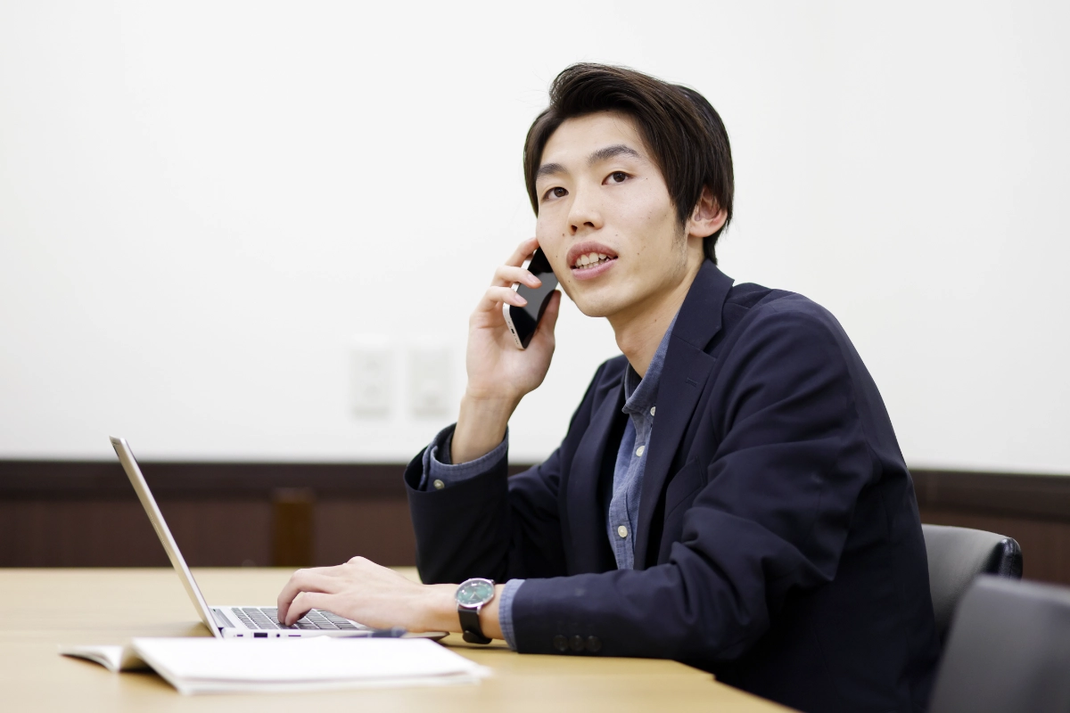 パソコン作業をしながら電話をしているN.H.さん